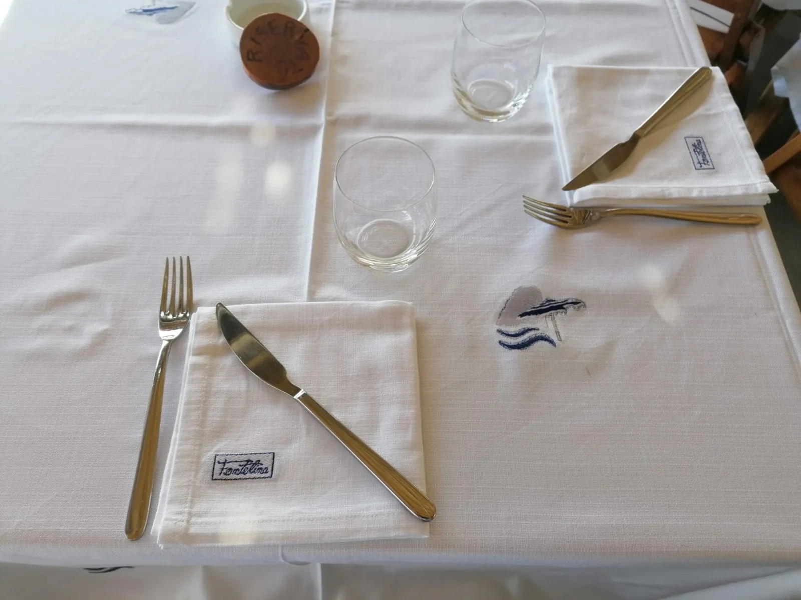 Tavola apparecchiata con tovagliato e tovaglioli ricamati Fontelina Beach Club — forniture hospitality Capuano