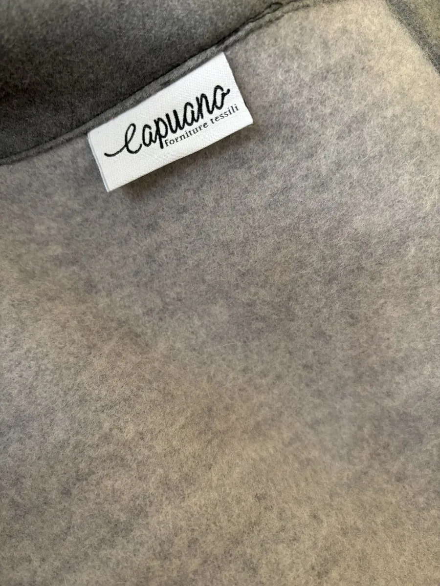 Etichetta Capuano Forniture Tessili su cashmere grigio