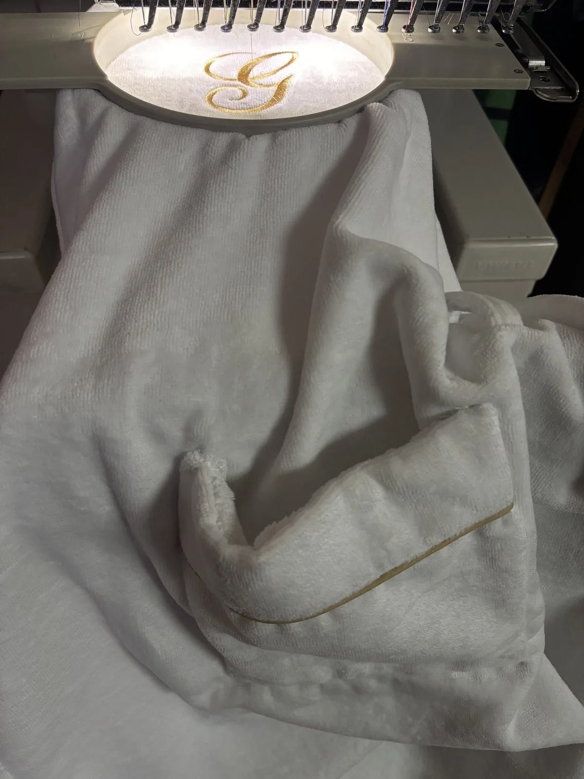 Monogramma Fontelina ricamato a mano su tovaglia — branding hospitality