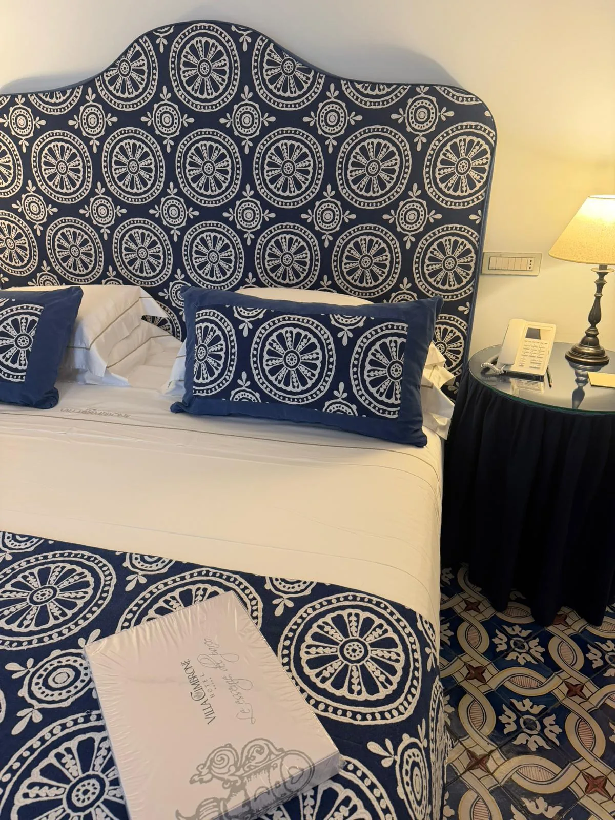 Camera d'hotel con completo letto e testiera a medaglioni blu e bianco — Villa Cimbrone
